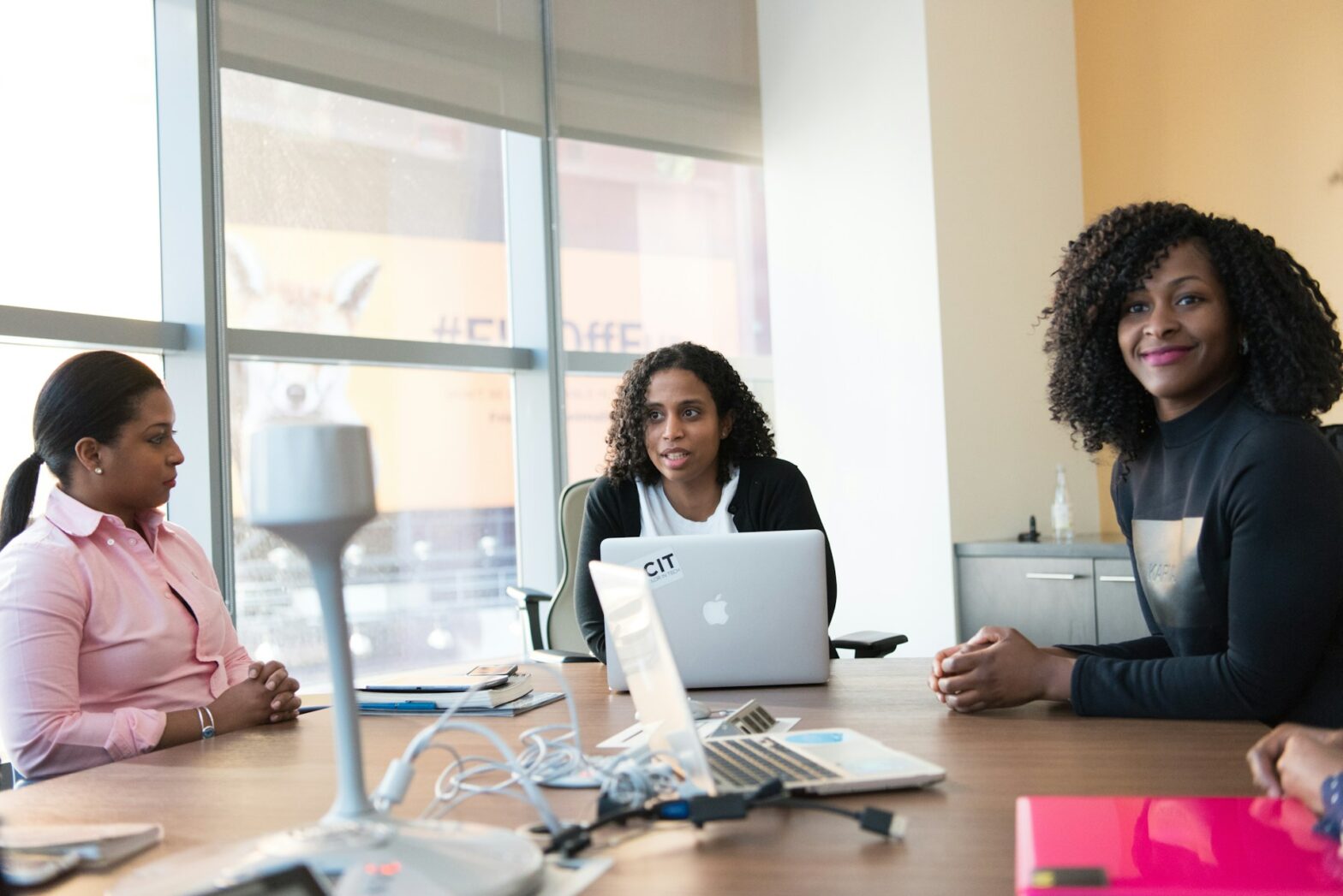 Three women sitting in front of a table
