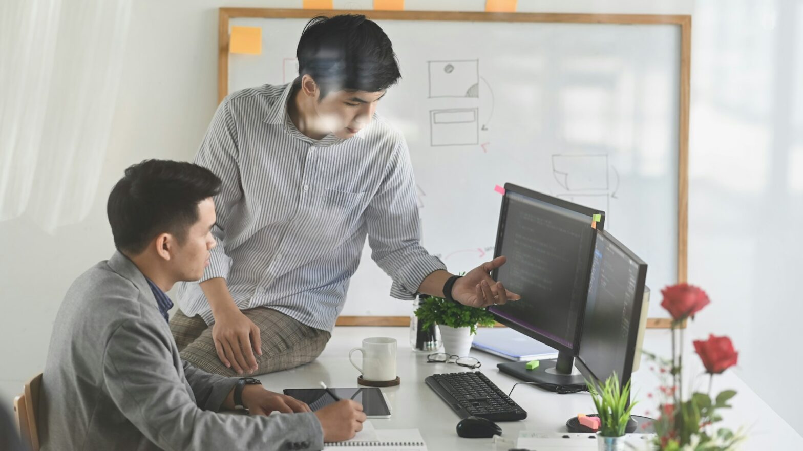 Two person talking in front of a computer